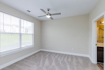 a bedroom with two windows and a ceiling fan at The Flats at Summit Station, South Park, Pennsylvania